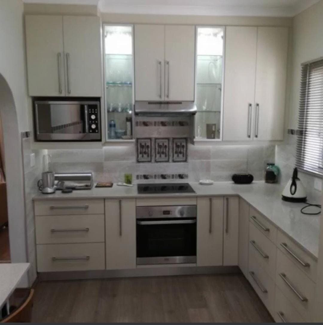 Kitchen renovation with cream cabinetry, built-in oven and induction hob