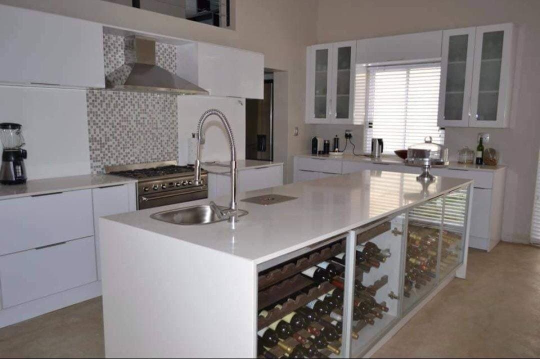 Kitchen renovation with a white island, gas range and subway tile splashback