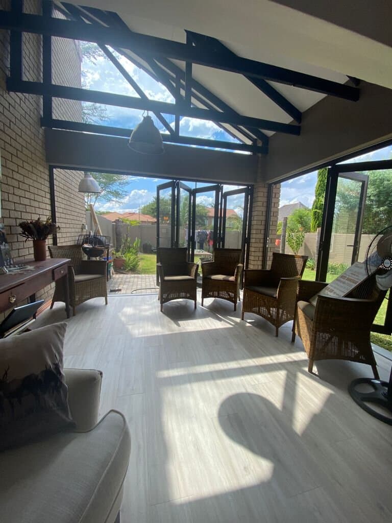 Enclosed patio with stacking aluminium doors opening onto the garden